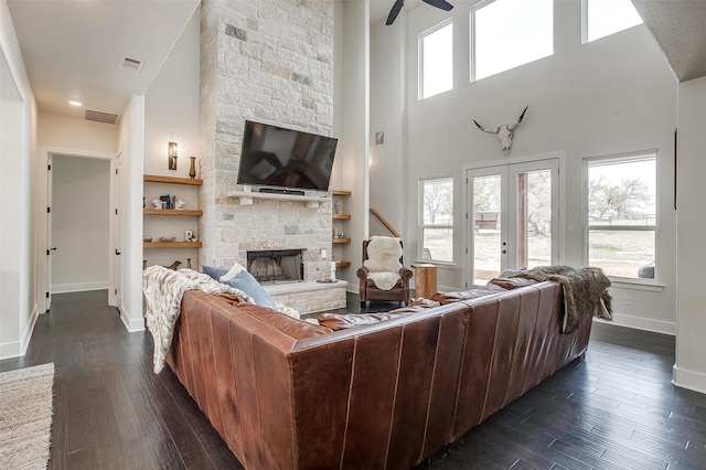201 Flat Rock Ln, Weatherford, TX 76088 - living area with baseboards, a stone fireplace, ceiling fan, dark wood-type flooring, and a high ceiling