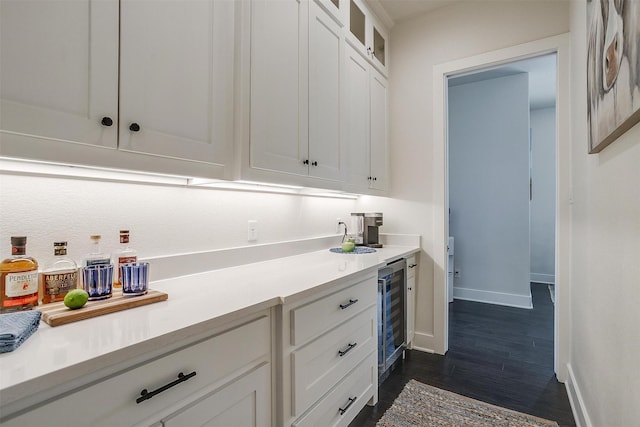 201 Flat Rock Ln, Weatherford, TX 76088 - kitchen featuring wine cooler, light countertops, baseboards, glass insert cabinets, and dark wood-type flooring