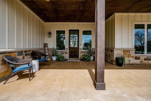 201 Flat Rock Ln, Weatherford, TX 76088 - view of exterior entry featuring board and batten siding, a patio area, and stone siding