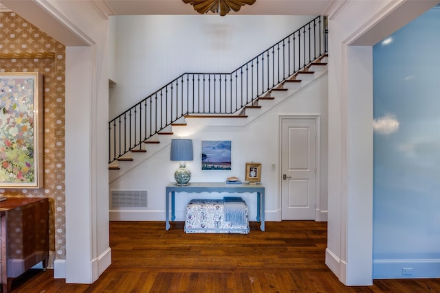 stairway with wood finished floors, visible vents, and baseboards