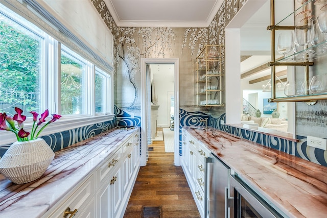bar with beverage cooler, visible vents, wallpapered walls, dark wood-style flooring, and ornamental molding