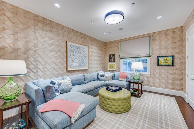 living area with wallpapered walls, wood finished floors, baseboards, and ornamental molding