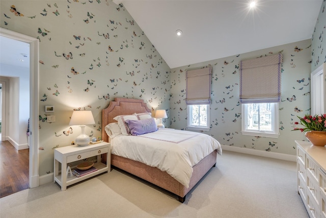bedroom featuring wallpapered walls, high vaulted ceiling, baseboards, and light carpet