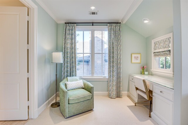 sitting room featuring built in desk, plenty of natural light, and crown molding