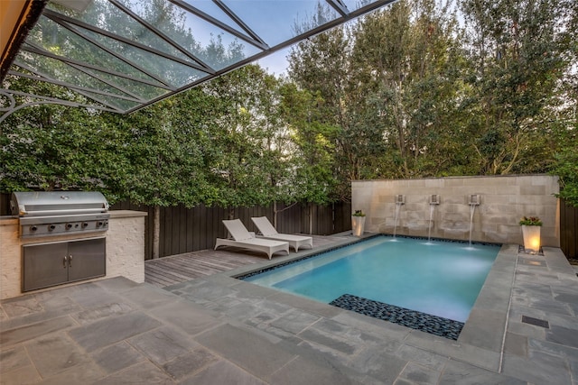 view of swimming pool featuring a fenced backyard, an outdoor kitchen, a grill, and a patio