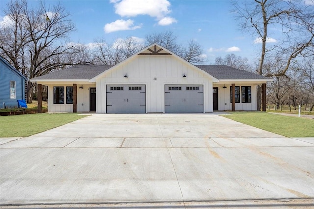 modern farmhouse featuring a garage, board and batten siding, and a front yard