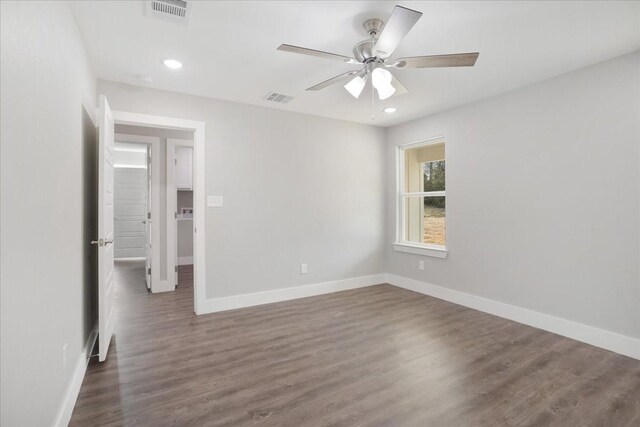 unfurnished room featuring visible vents, baseboards, dark wood-type flooring, and ceiling fan
