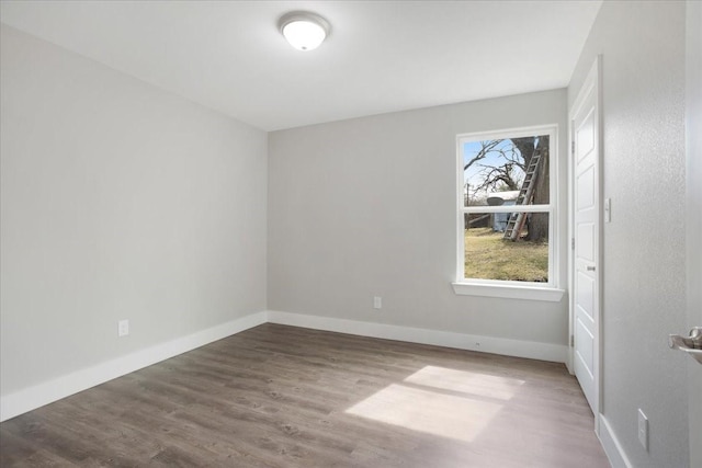 empty room with baseboards and wood finished floors