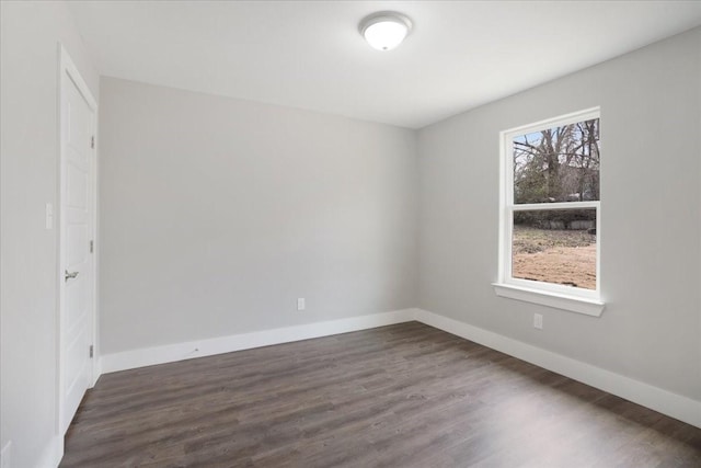 empty room with baseboards and dark wood-style flooring