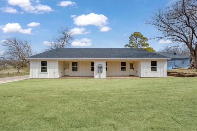 view of front of property featuring a front lawn, board and batten siding, and roof with shingles