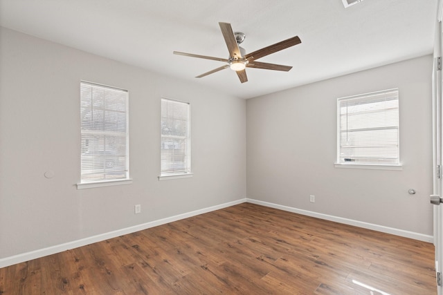 empty room featuring baseboards, a ceiling fan, and wood finished floors