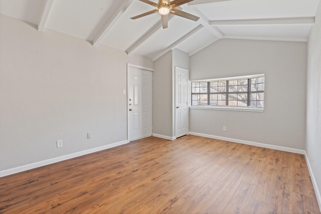 empty room with baseboards, wood finished floors, ceiling fan, and vaulted ceiling with beams