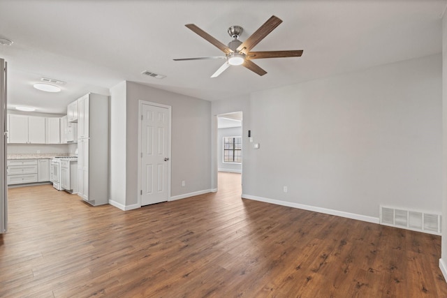 unfurnished living room with baseboards, wood finished floors, visible vents, and ceiling fan