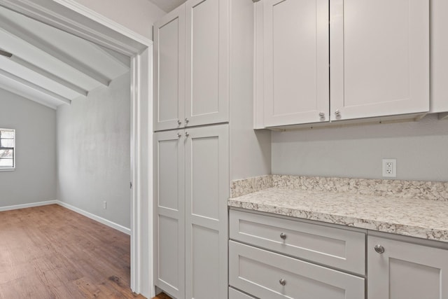 kitchen with lofted ceiling, light wood-style floors, and baseboards