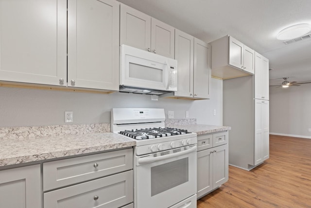 kitchen featuring light wood-type flooring, visible vents, white appliances, light countertops, and ceiling fan