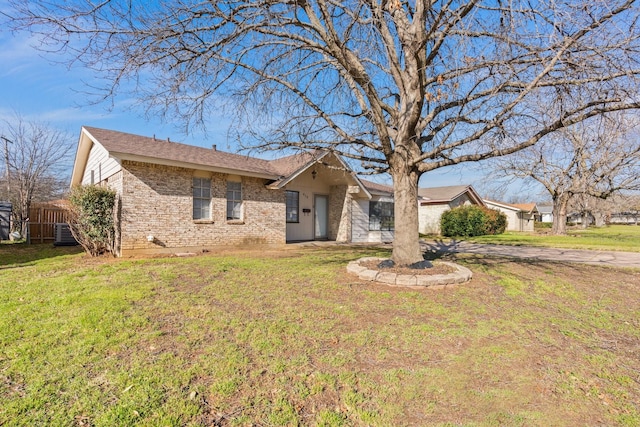 ranch-style home with a front lawn, fence, and brick siding