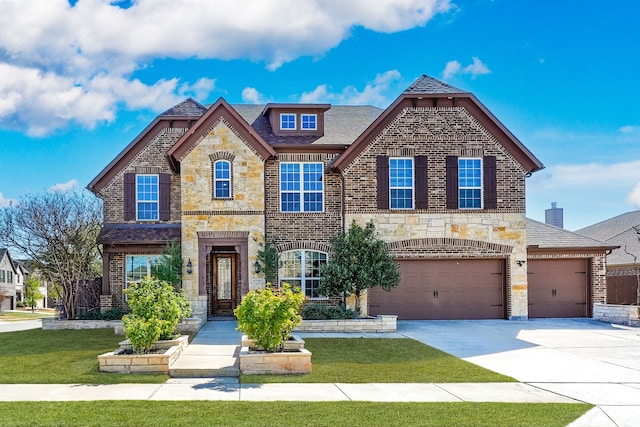 french country inspired facade featuring driveway, stone siding, an attached garage, brick siding, and a front lawn