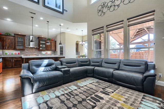 living room with a high ceiling, wood finished floors, recessed lighting, and visible vents