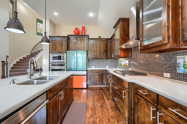 kitchen featuring wall chimney exhaust hood, light countertops, a sink, and stainless steel appliances