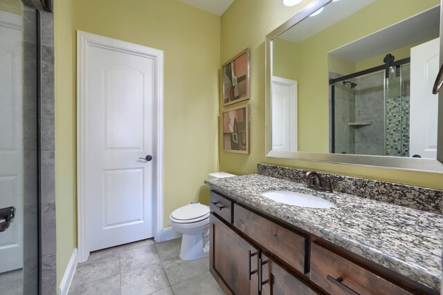full bathroom with a stall shower, tile patterned floors, toilet, vanity, and baseboards