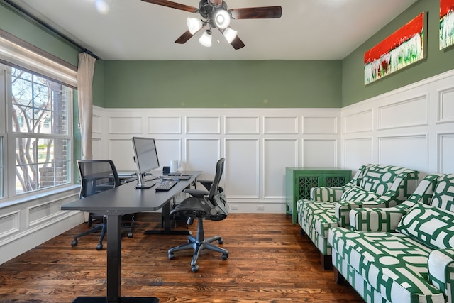 office area with dark wood finished floors, a decorative wall, and a ceiling fan