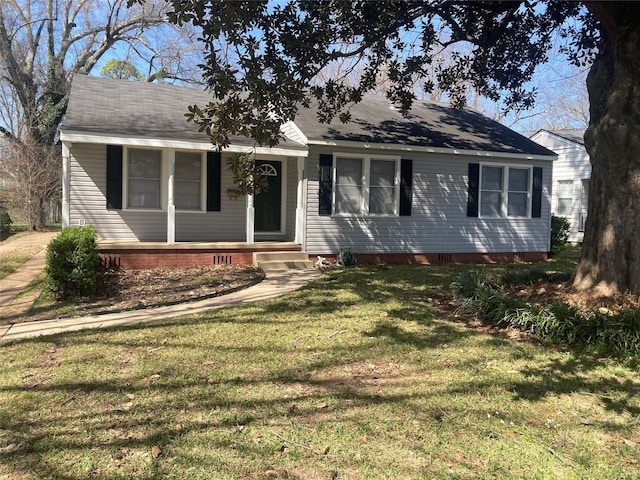 view of front of property with crawl space, a porch, roof with shingles, and a front yard