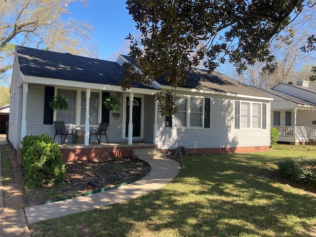 view of front of home featuring crawl space, covered porch, a shingled roof, and a front lawn