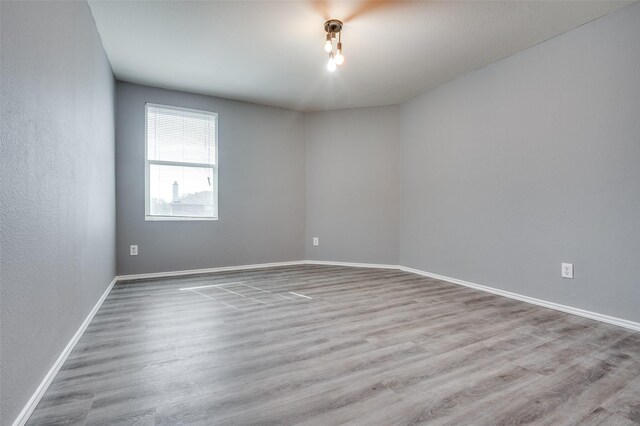 unfurnished room featuring baseboards and wood finished floors