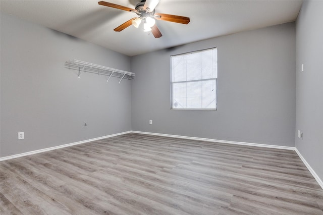 unfurnished room with wood finished floors, baseboards, and ceiling fan
