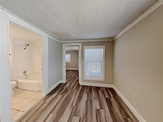 spare room with wood finished floors, baseboards, and a textured ceiling
