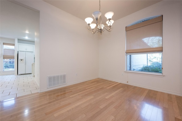 1505 Valley Creek Rd, Denton, TX 76205 - empty room featuring a chandelier, light wood-type flooring, and baseboards
