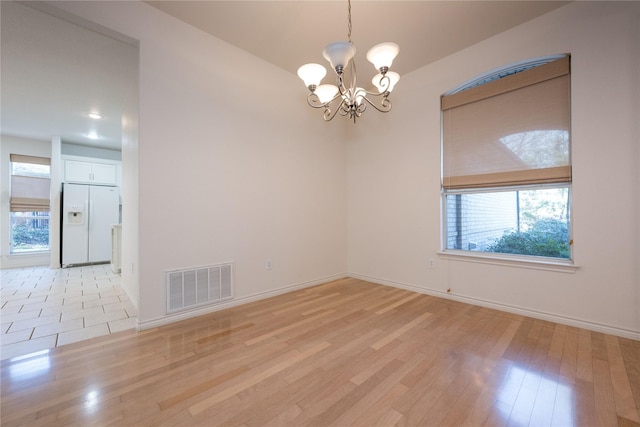 1505 Valley Creek Rd, Denton, TX 76205 - empty room featuring a chandelier, light wood-type flooring, and baseboards