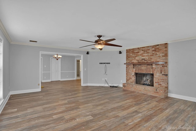 unfurnished living room with wood finished floors, a brick fireplace, and ornamental molding