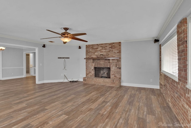 unfurnished living room featuring ceiling fan, wood finished floors, ornamental molding, and a fireplace