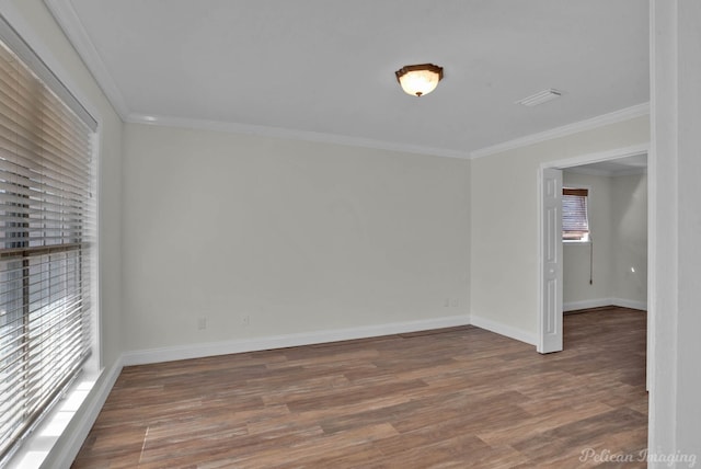 spare room with wood finished floors, baseboards, and ornamental molding