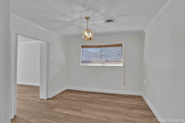 spare room with visible vents, baseboards, wood finished floors, and crown molding