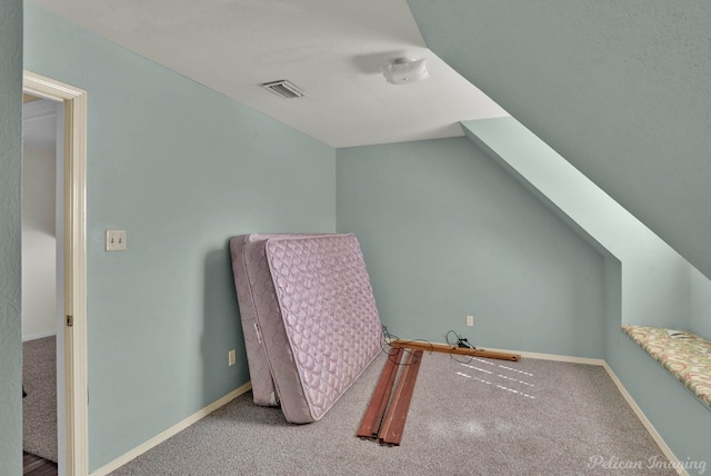 additional living space with vaulted ceiling, carpet flooring, baseboards, and visible vents