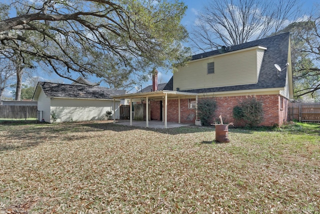 rear view of property with a patio area, a lawn, brick siding, and fence