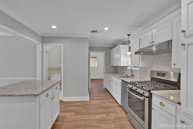 kitchen with visible vents, crown molding, under cabinet range hood, stainless steel appliances, and a sink