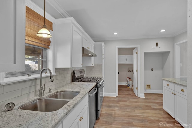 kitchen with under cabinet range hood, a sink, backsplash, appliances with stainless steel finishes, and white cabinets