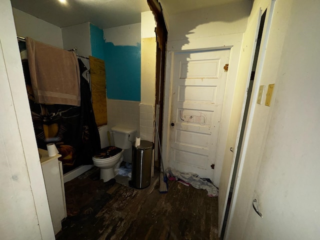 bathroom featuring a shower, toilet, and wood finished floors