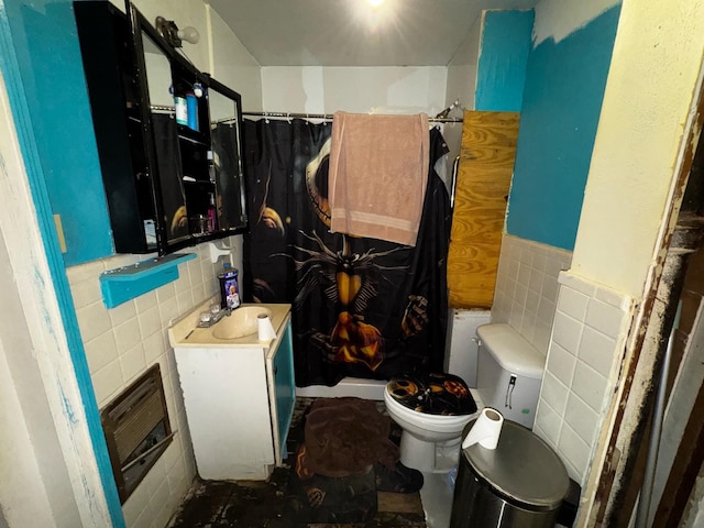 full bath featuring a shower with curtain, toilet, tile walls, wainscoting, and vanity