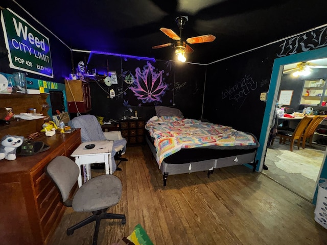 bedroom with wood-type flooring and a ceiling fan