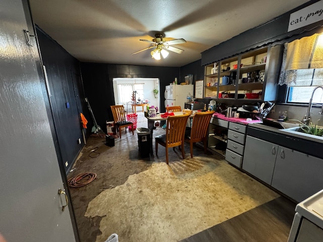 kitchen featuring wood finished floors, open shelves, freestanding refrigerator, a sink, and ceiling fan