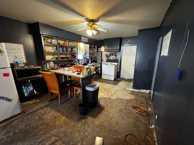 kitchen featuring a ceiling fan, stainless steel microwave, freestanding refrigerator, a peninsula, and range