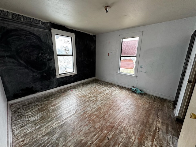 unfurnished bedroom with baseboards and wood-type flooring