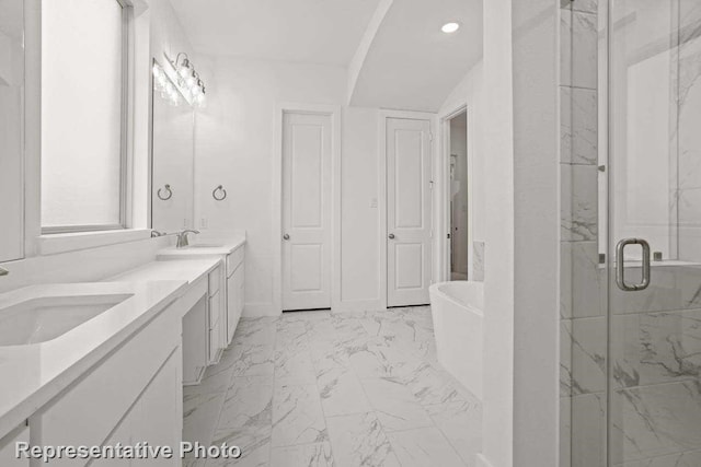 bathroom with a marble finish shower, marble finish floor, a freestanding bath, and a sink