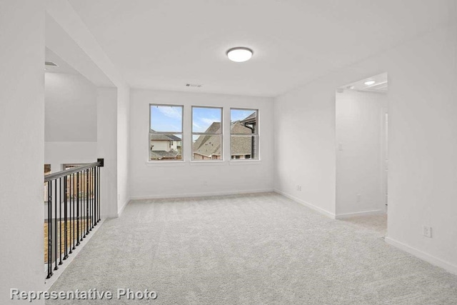 empty room featuring baseboards and carpet