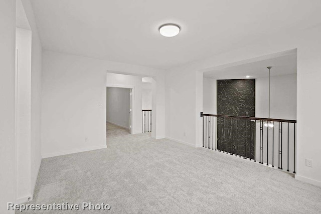 carpeted spare room featuring baseboards