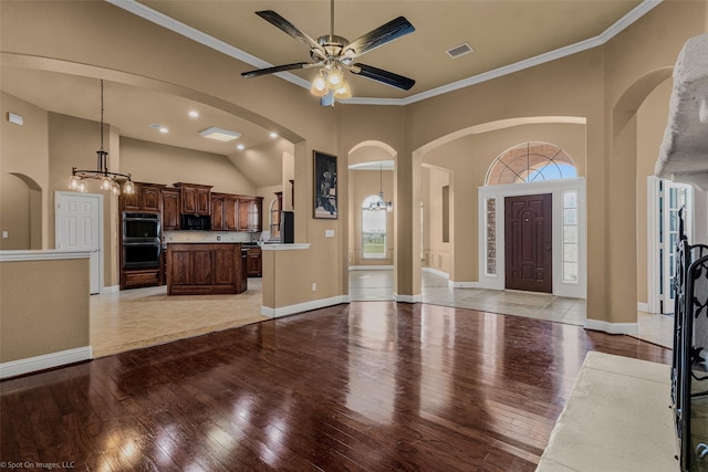 477 Horseshoe Bnd, Royse City, TX 75189 - unfurnished living room featuring light wood-style flooring, arched walkways, a chandelier, ceiling fan, and crown molding